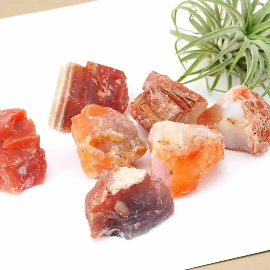 Raw Carnelian stones in vibrant orange and red-brown, featuring natural, unpolished textures for courage and creativity.