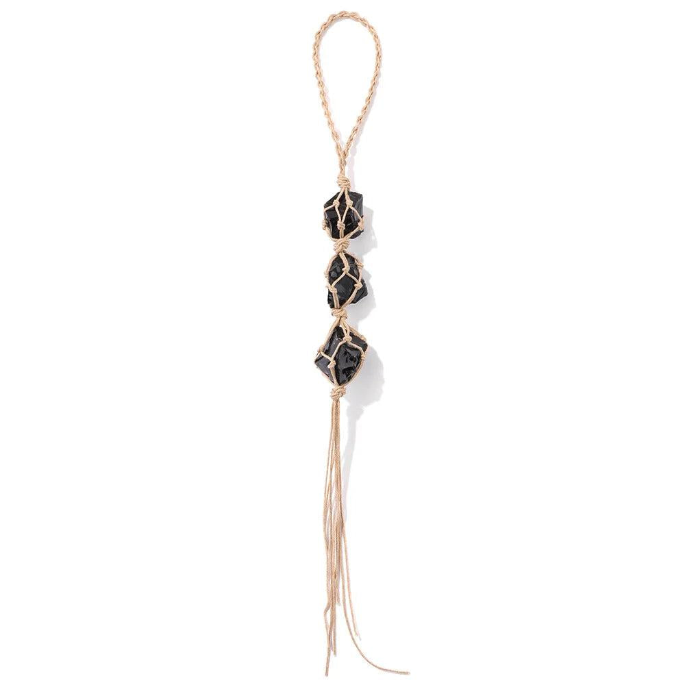 Three raw black tourmaline stones wrapped in natural twine, forming a car rearview mirror pendant.