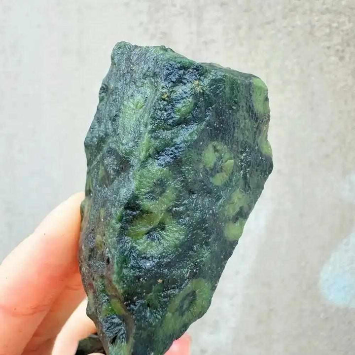 Raw Kambaba Jasper stone featuring dark green and black orb patterns, perfect for grounding and heart chakra healing.