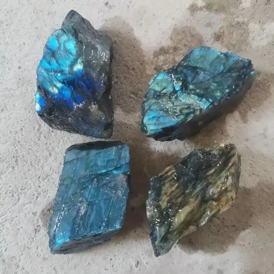 Four raw Labradorite rough crystals from Crystal Destiny, displaying iridescent blue, green, and gold flashes.