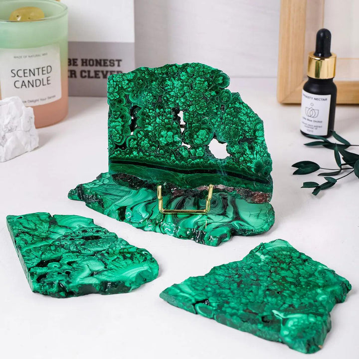 Raw Malachite pieces featuring vivid green bands and eye-like rings, perfect for heart chakra healing and home decor.