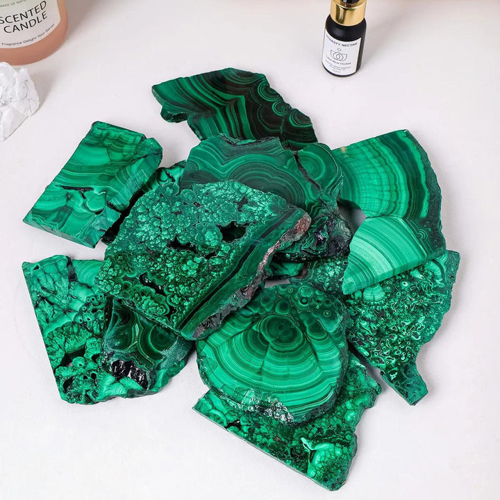 Raw Malachite pieces featuring vivid green bands and natural eye-like rings, perfect for Heart Chakra transformation.