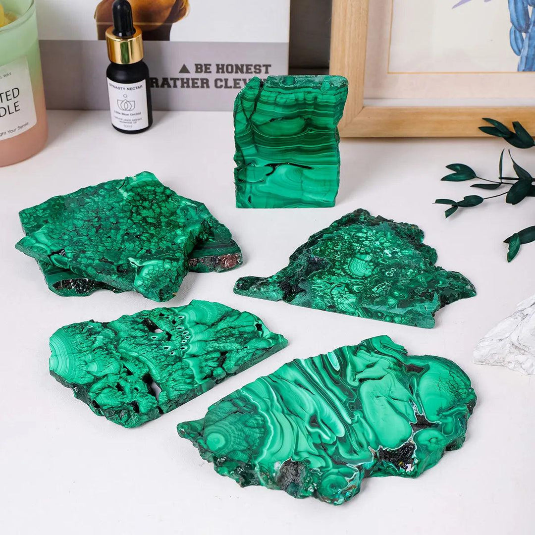 Raw Malachite pieces featuring vivid green bands and eye-like rings, perfect for Heart Chakra healing and home decor.
