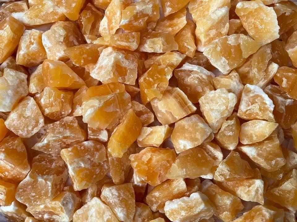 Raw orange calcite stones with a vibrant, waxy glow, perfect for sacral chakra energy and creative home decor accents.