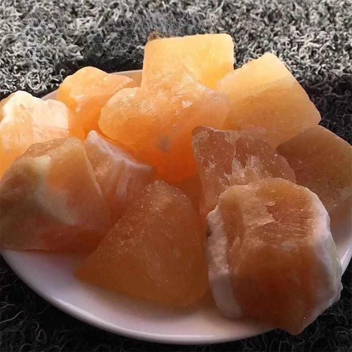 Raw orange calcite pieces with a vibrant, waxy glow, perfect for sacral chakra energy and creative home decor.