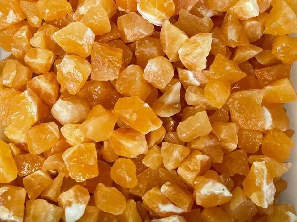 Raw orange calcite crystals with vibrant, waxy textures, perfect for sacral chakra energy and creative home decor.