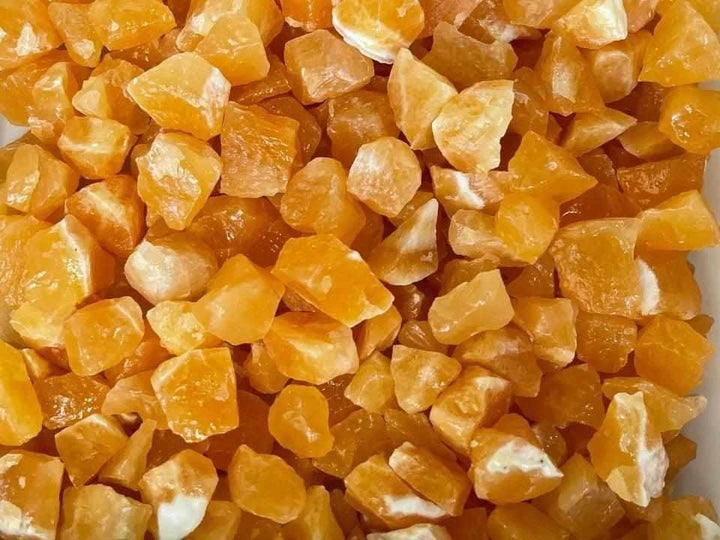 Raw orange calcite crystals with vibrant, waxy textures, perfect for sacral chakra energy and creative home decor.