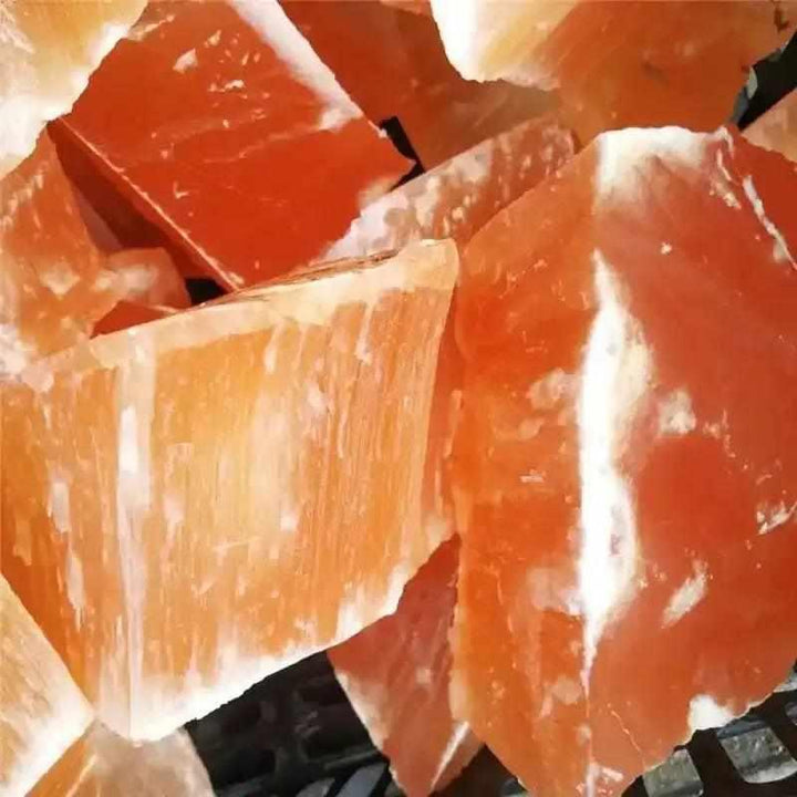 Raw orange selenite chunk with silky, fibrous texture and warm peach tones for sacral chakra healing and home decor.