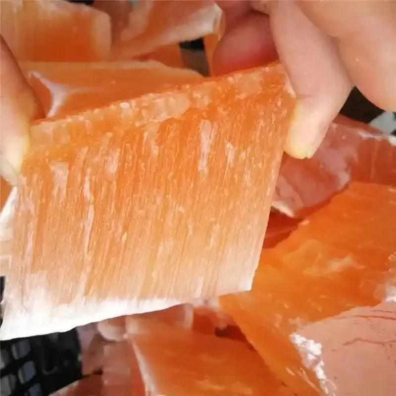 Raw orange selenite chunk with silky, fibrous texture and warm peach tones, perfect for sacral chakra energy cleansing.