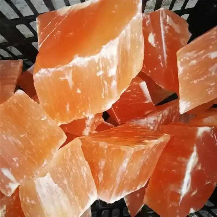 Raw orange selenite chunks with silky, peach-toned fibers for sacral chakra healing and creative energy.