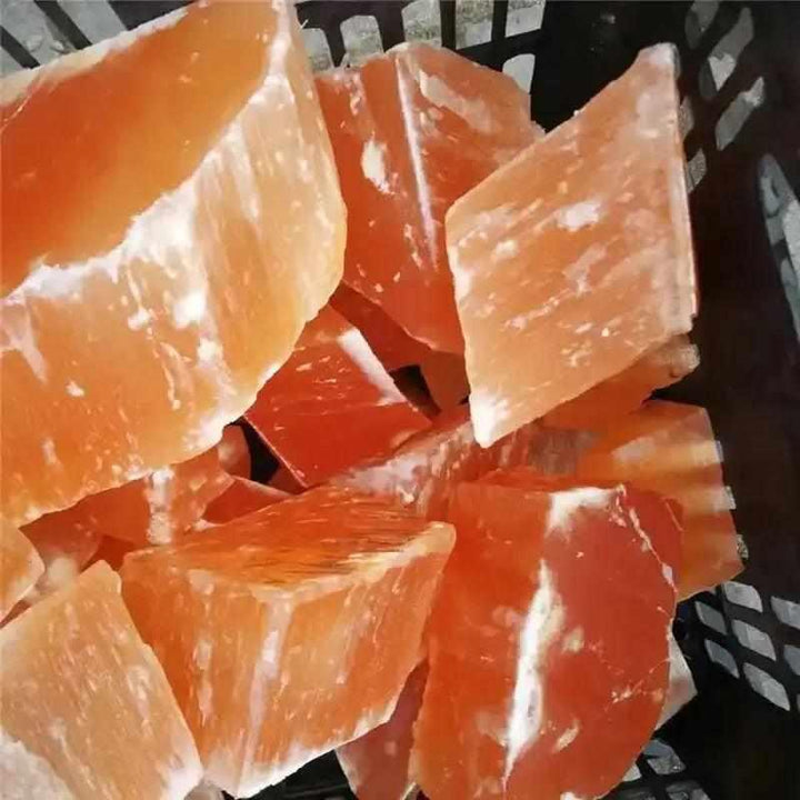 Raw orange selenite chunks with silky, peach-toned fibers and a natural, glowing texture for sacral chakra healing.
