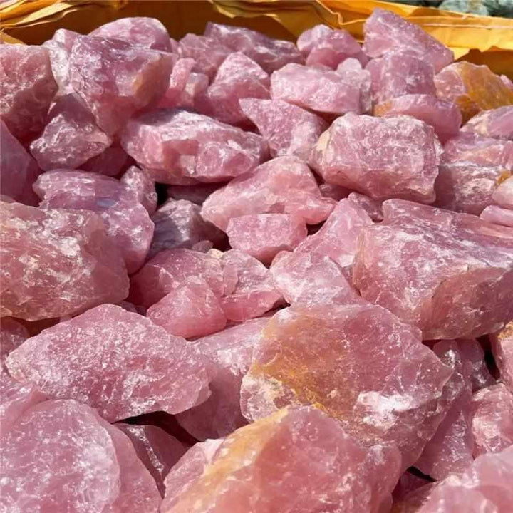 Raw rose quartz chunks with a soft pink hue and natural, unpolished rough surfaces for heart chakra healing and decor.