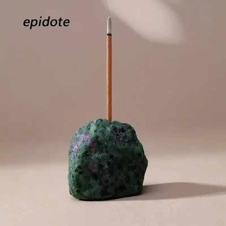Raw stone incense holder in green epidote with a rough, textured surface and a slender incense stick for your ritual.