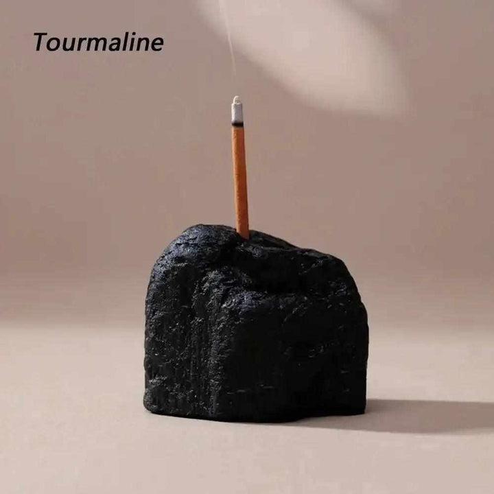 Rough black tourmaline stone incense holder with a raw, textured surface for grounding rituals and mindful meditation.