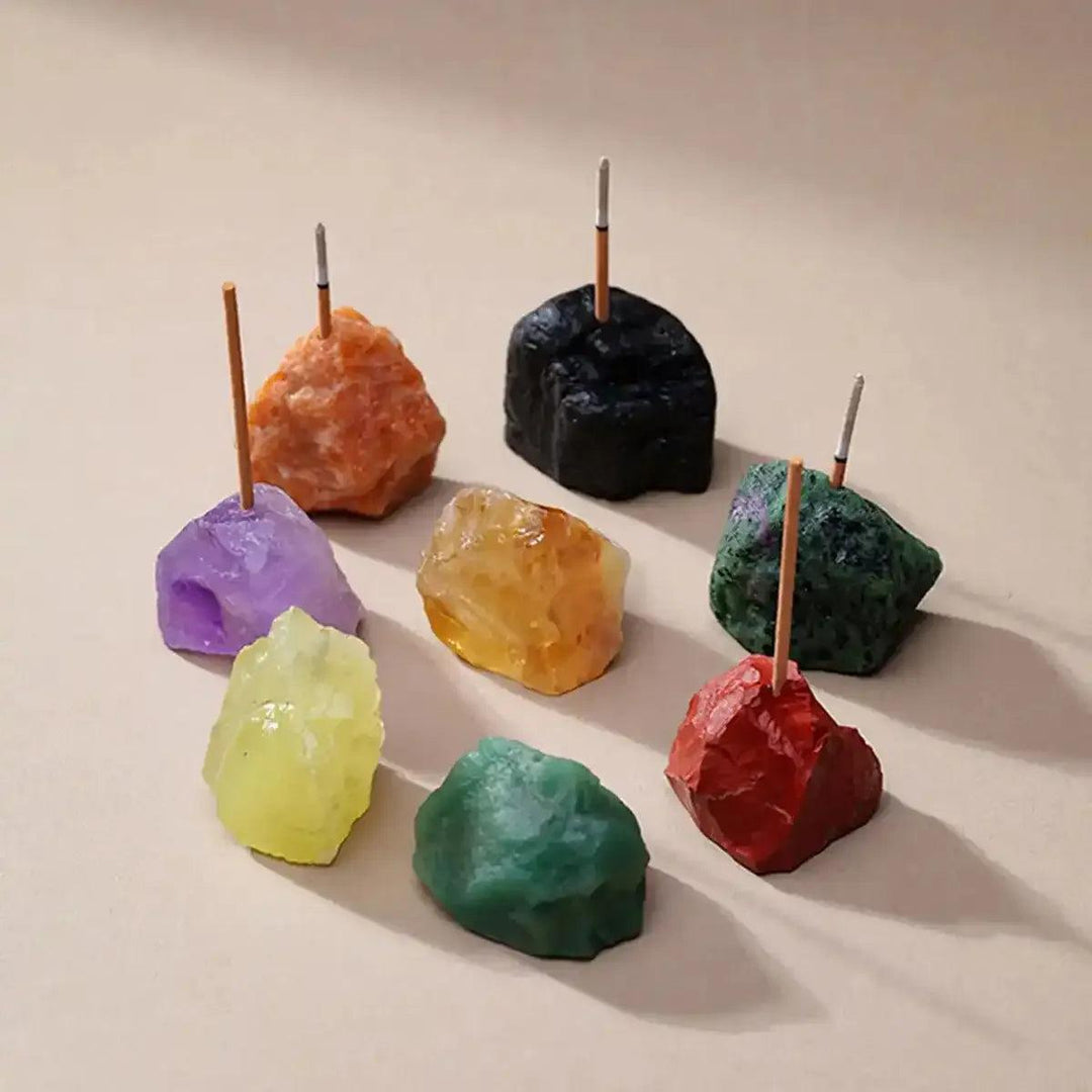 Raw stone incense holders in assorted colorful crystals like amethyst and citrine with rough, mineral-textured surfaces.
