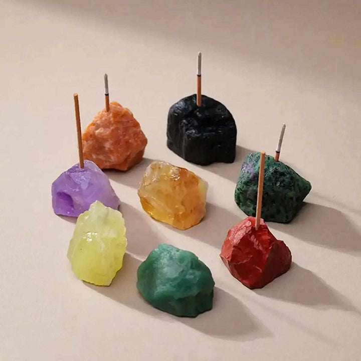 Raw stone incense holders in assorted colorful crystals like amethyst and citrine with rough, mineral-textured surfaces.