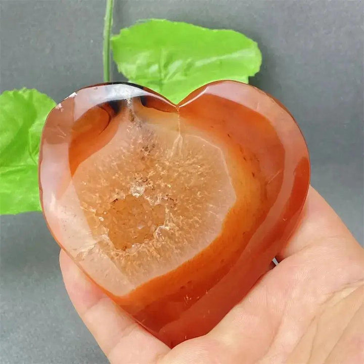 Natural Red Agate Heart Geode: Polished red agate heart with sparkling druzy crystal interior, held in hand.