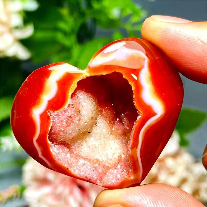 Polished red agate heart-shaped crystal geode with sparkling quartz pocket for healing energy.