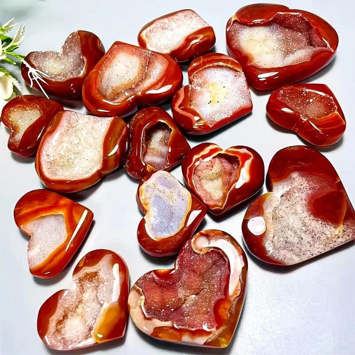 Polished red agate heart-shaped stones with sparkling natural crystal geode centers.