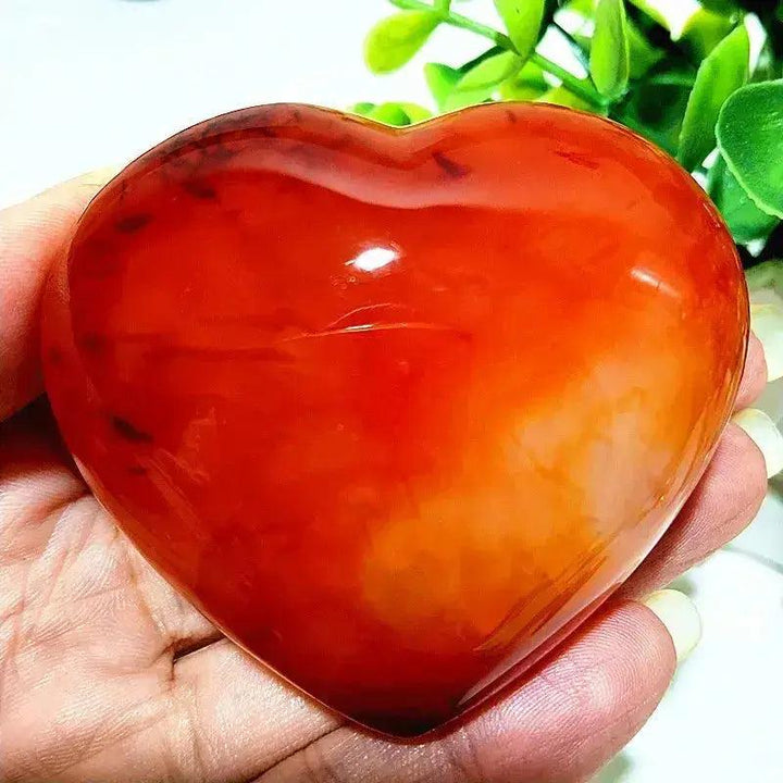 Polished Red Agate Heart, Root Chakra, Grounding Vitality Stone, held in hand, showcasing rich red tones.