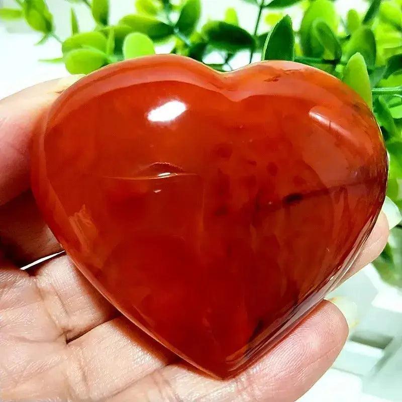 Polished Red Agate Heart, a vibrant root chakra grounding vitality stone, held in a hand.