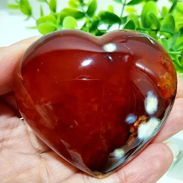Polished Red Agate Heart, a vibrant root chakra grounding vitality stone, held in a hand.