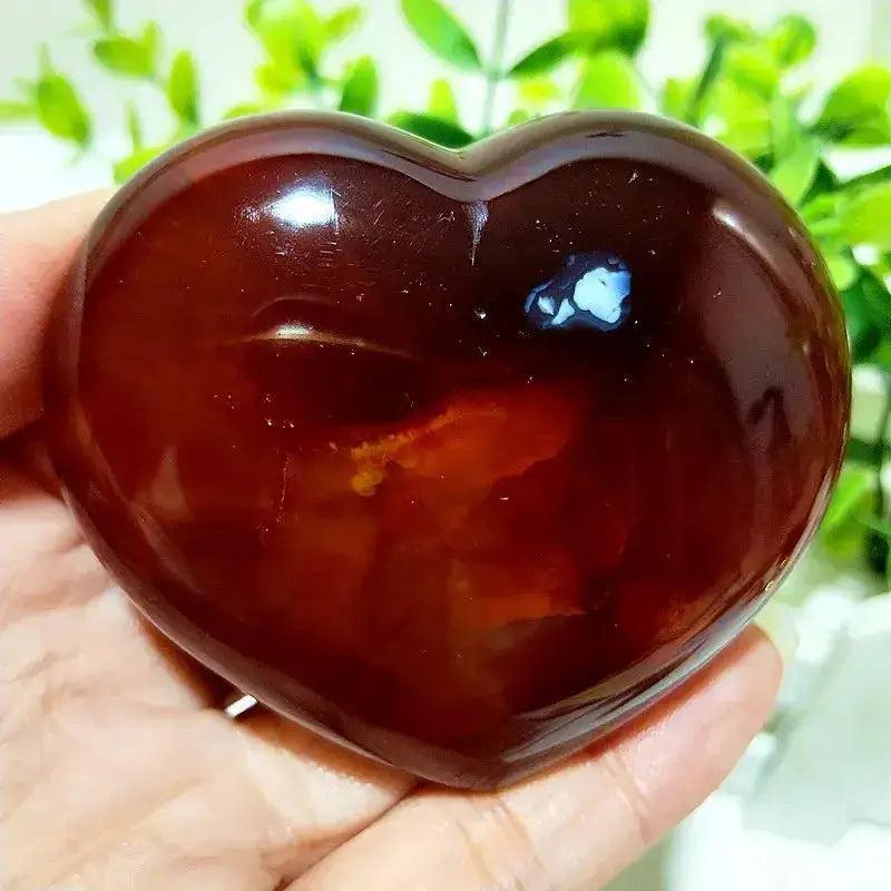 Polished Red Agate Heart, Root Chakra, grounding vitality stone, held in hand.