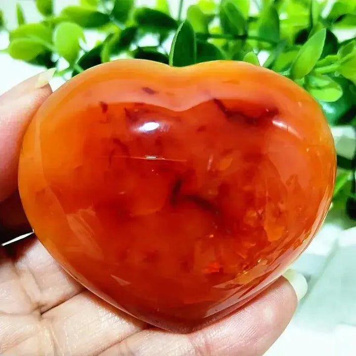 Polished Red Agate Heart, a vibrant Root Chakra grounding vitality stone, held in a hand.