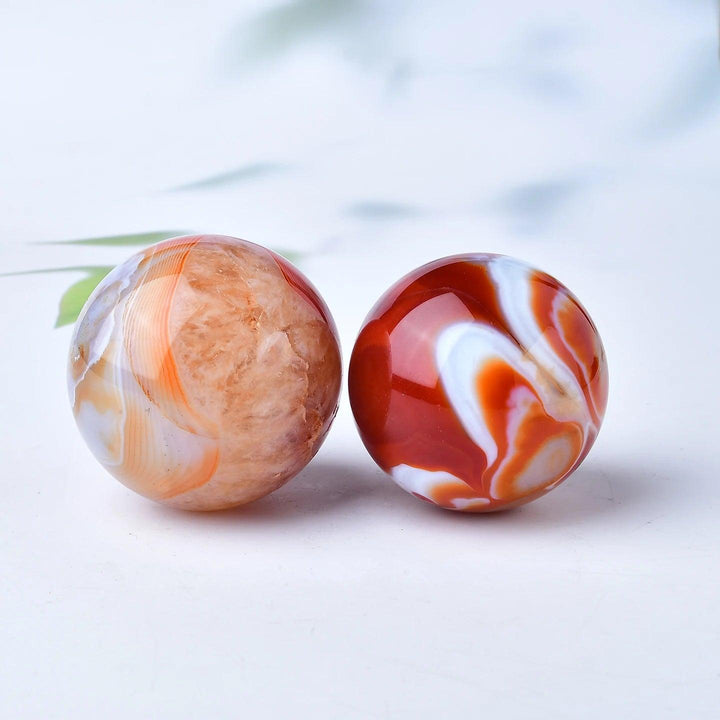 Two polished Red Banded Agate crystal spheres, one with warm terracotta tones, the other deep crimson and white, for grounding.