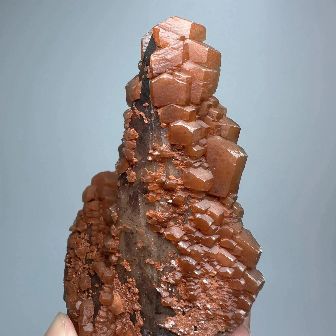 Vibrant red calcite crystal cluster with stacked cubic formations, a rare collector's specimen for energy and vitality.