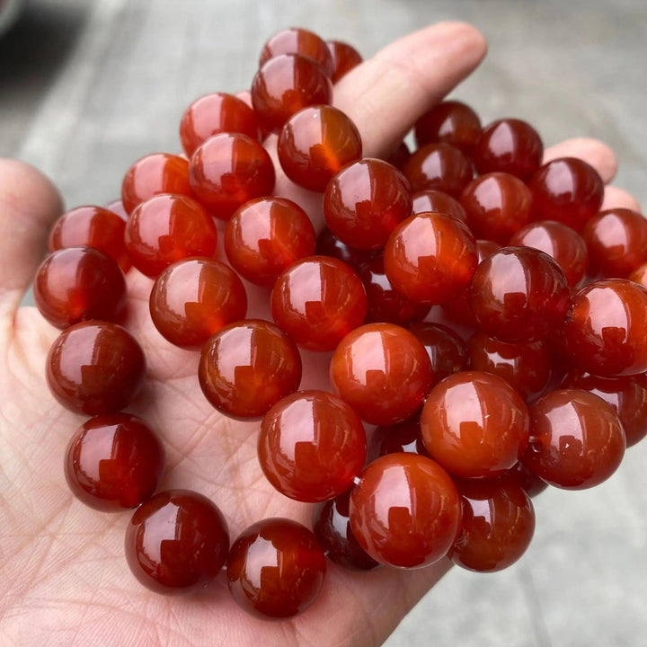 Genuine red carnelian stretch bracelet with polished, fiery orange beads for grounding energy and bold style.