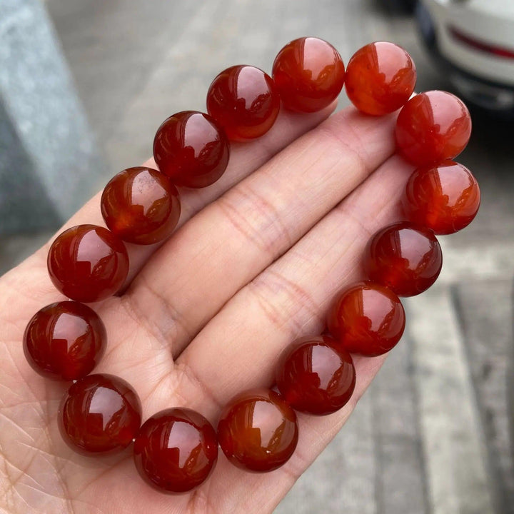Red Carnelian crystal stretch bracelet with glossy, burnt-orange beads for grounding energy and bold, fiery style.