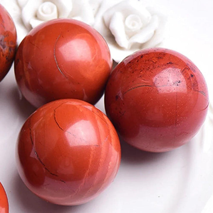 Three polished Red Jasper crystal spheres, deep brick-red with earthy tones, for grounding and vitality.