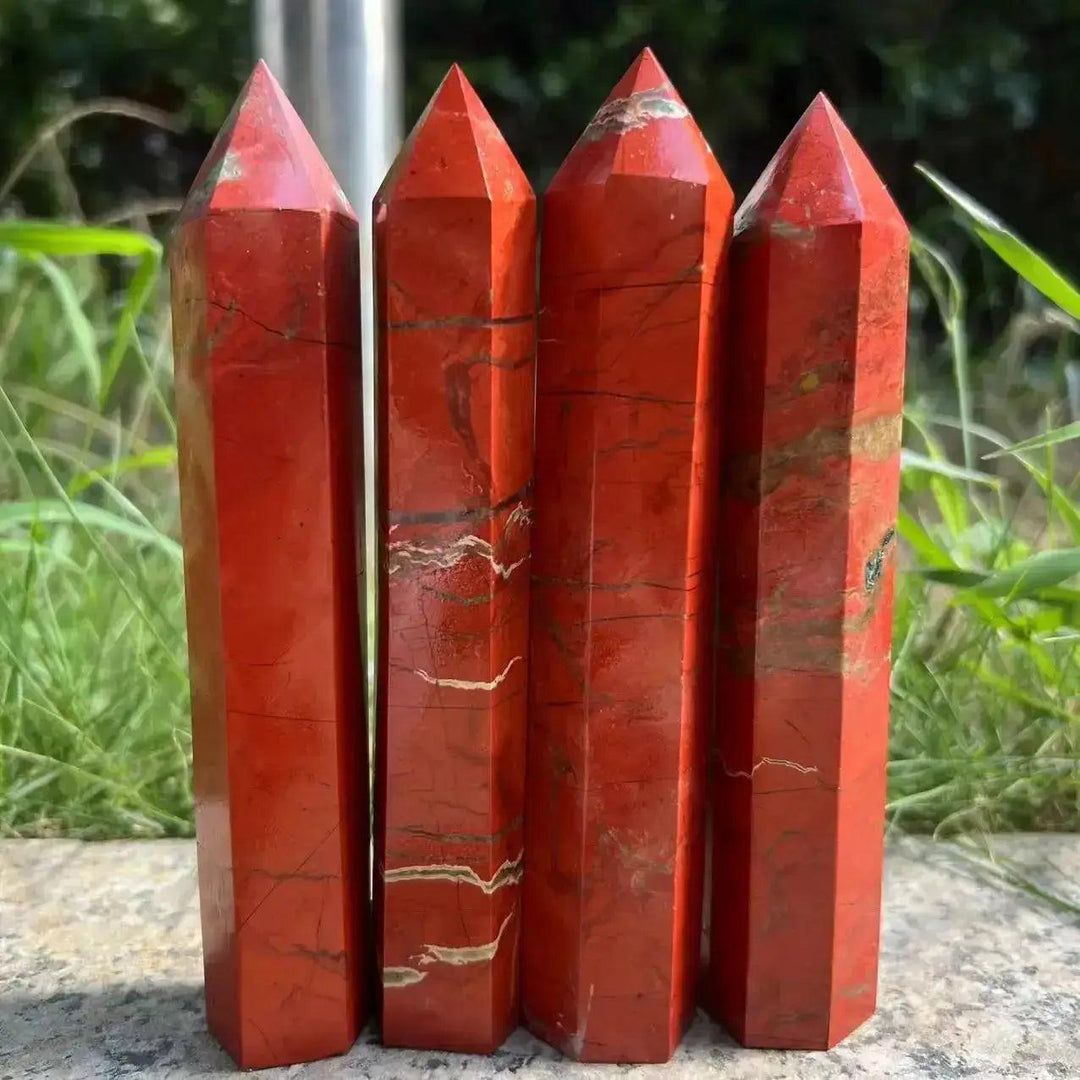 Four tall, polished Red Jasper Crystal Destiny towers with earthy red tones and natural striations.