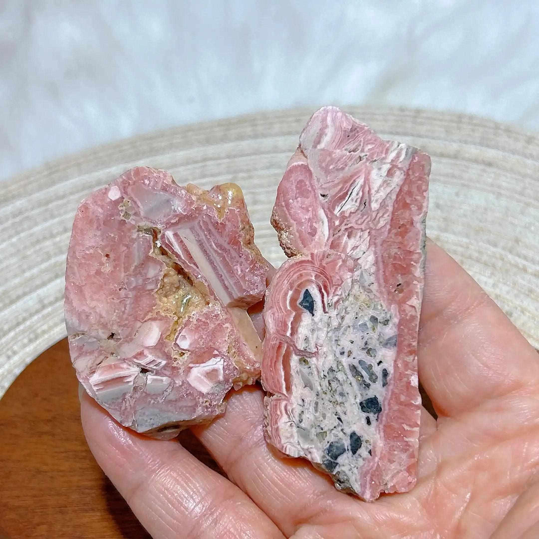 Polished Rhodochrosite raw slab featuring rose-pink banding and natural edges for heart chakra healing and display.