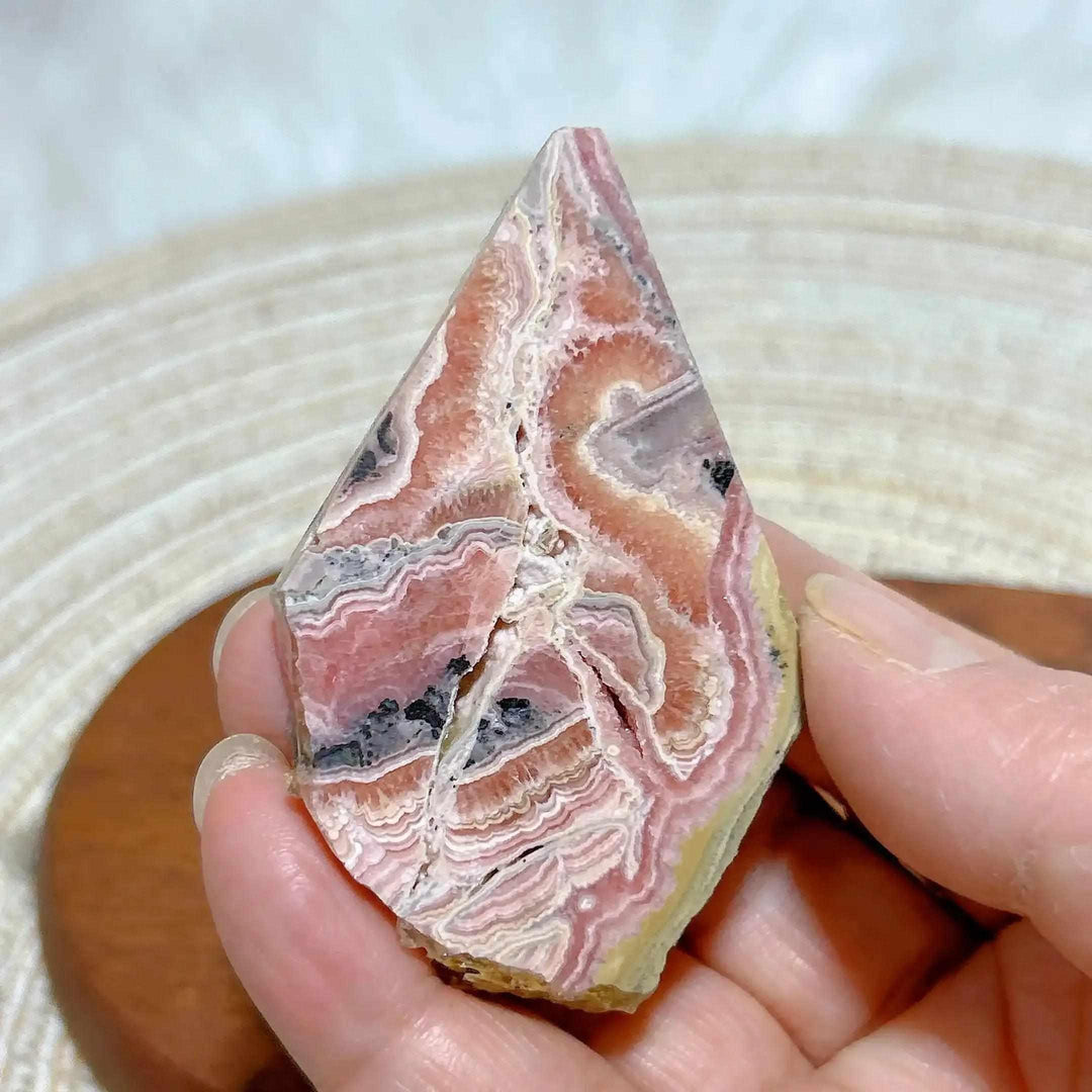 Polished Rhodochrosite raw slab featuring vibrant raspberry pink banding for heart chakra healing and display.
