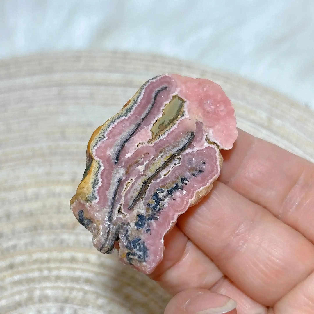 Polished Rhodochrosite raw slab featuring rose-pink banding for heart chakra healing and beautiful crystal display.