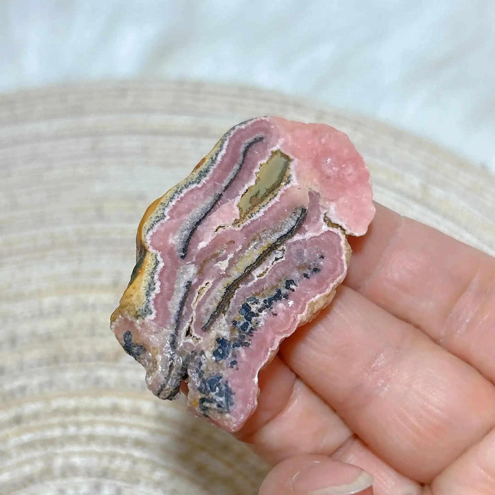 Polished Rhodochrosite raw slab featuring rose-pink banding for heart chakra healing and beautiful crystal display.