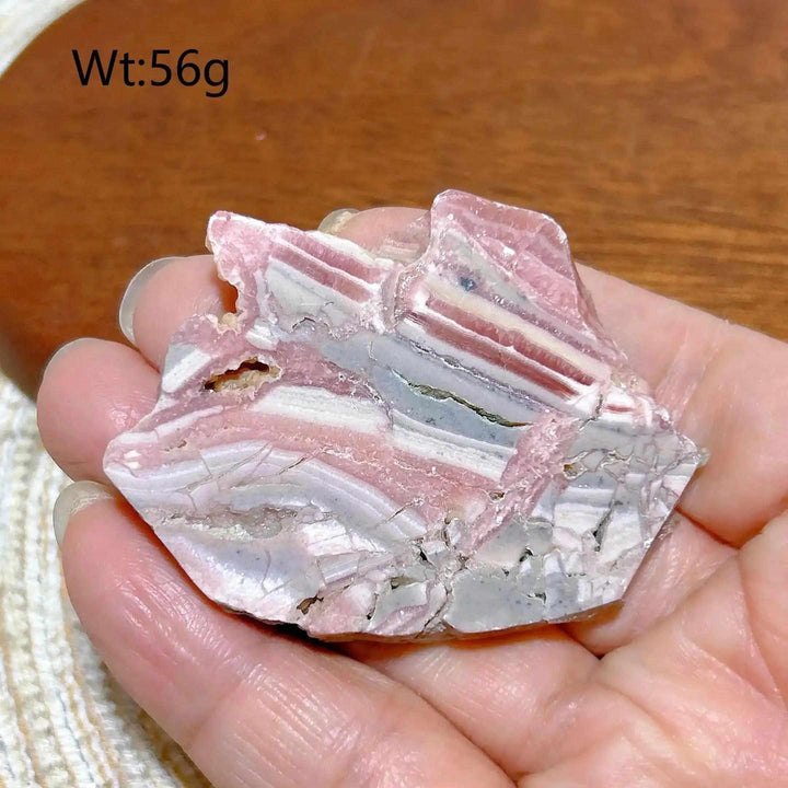 Polished Rhodochrosite raw slab featuring rose pink and white banding for emotional healing and heart chakra balance.