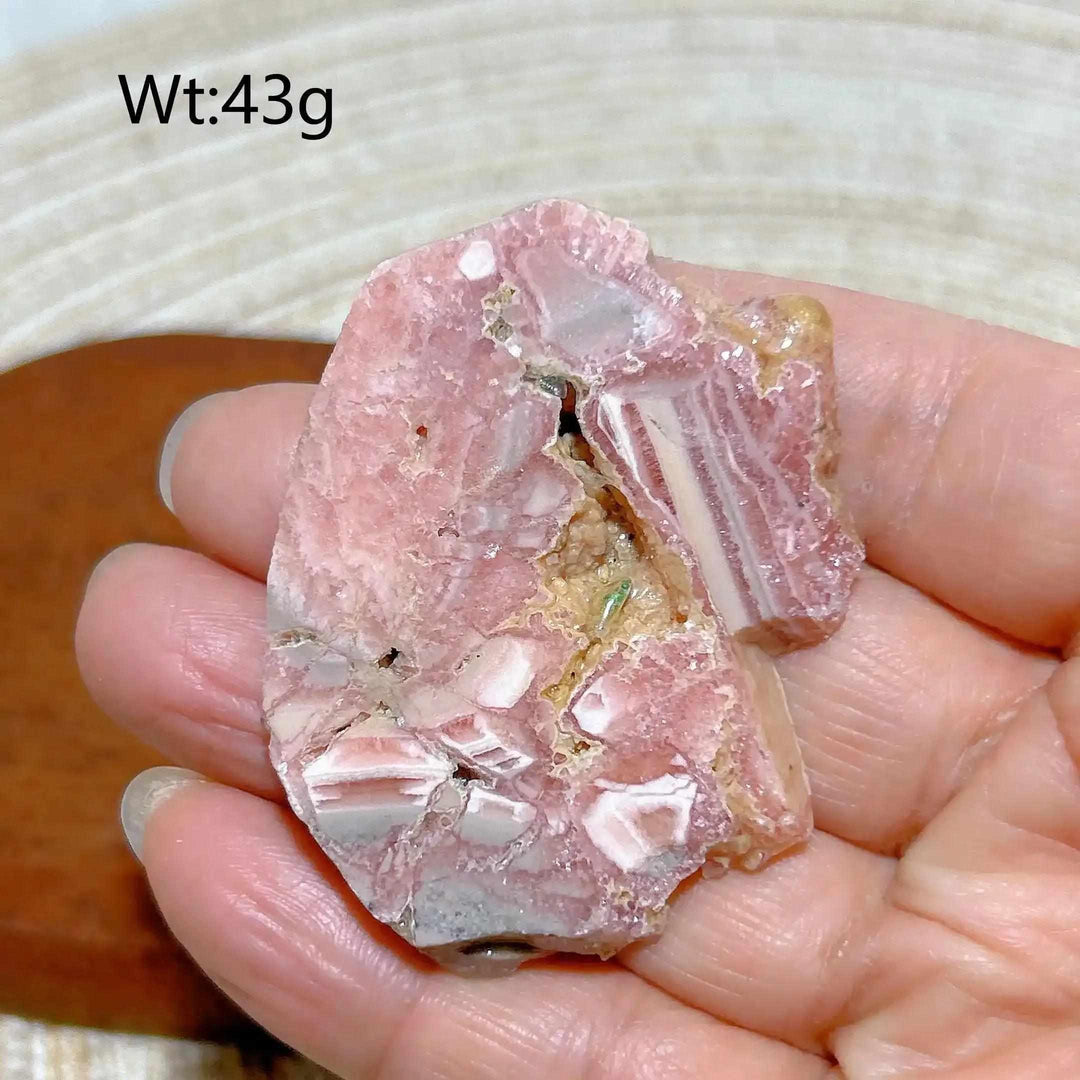 Polished Rhodochrosite raw slab featuring rose-pink banding and natural edges, perfect for heart chakra healing and display.