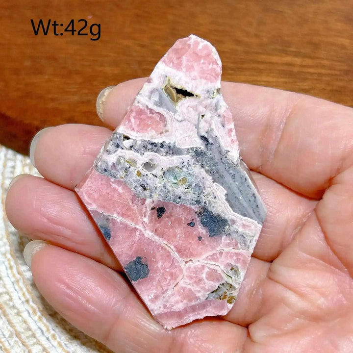 Polished Rhodochrosite raw slab featuring rose pink banding and natural edges, perfect for heart chakra healing.