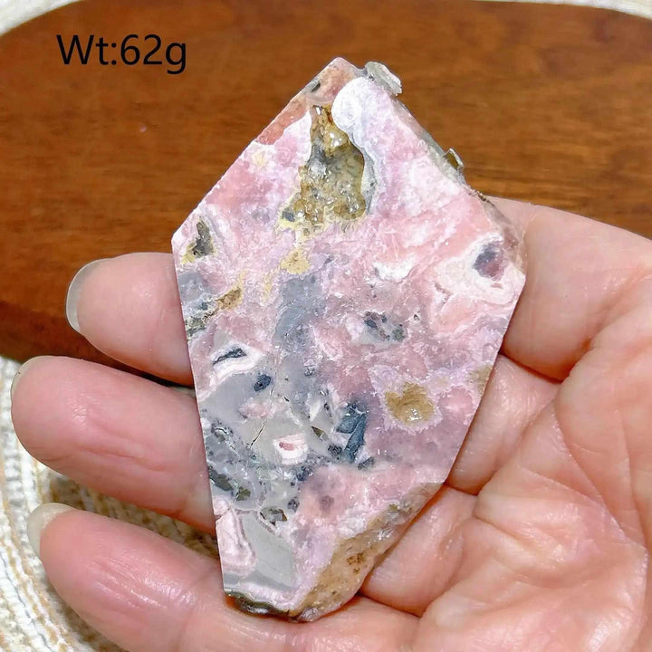 Polished Rhodochrosite raw slab featuring rose pink banding and natural edges, perfect for heart chakra healing.