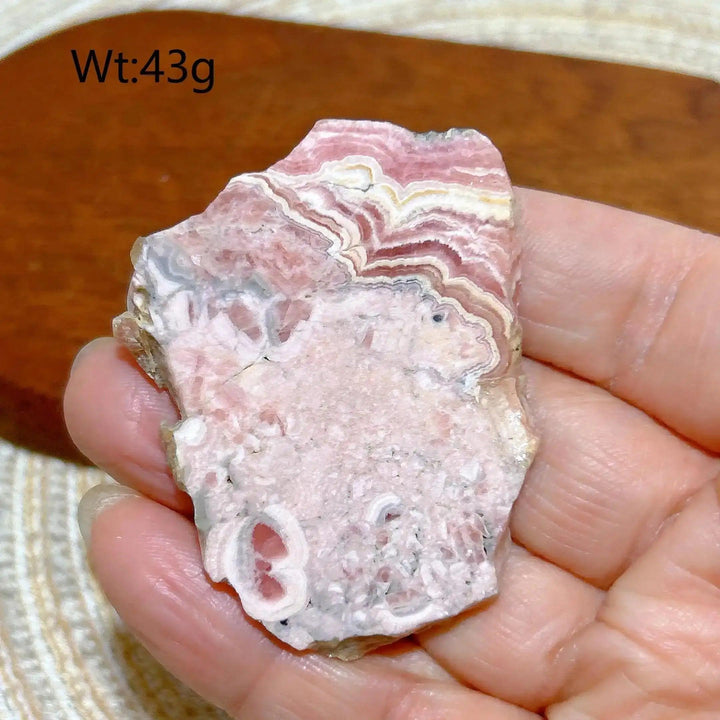 Polished Rhodochrosite raw slab featuring rose-pink banding for heart chakra healing and self-love display.