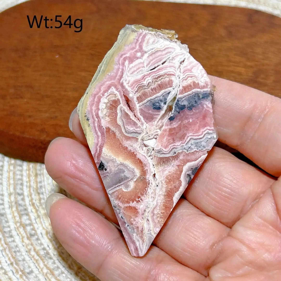 Polished Rhodochrosite raw slab featuring raspberry pink banding for heart chakra healing and beautiful display.