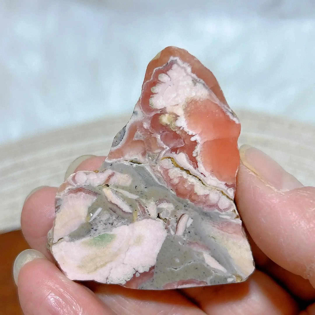 Polished Rhodochrosite raw slab featuring rose-pink and raspberry banding for heart chakra healing and display.