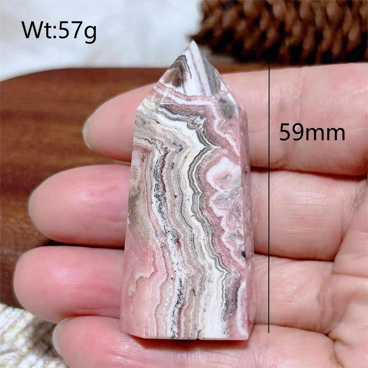 Polished Rhodochrosite tower point featuring rose pink and white banding, perfect for heart chakra healing and self-love.