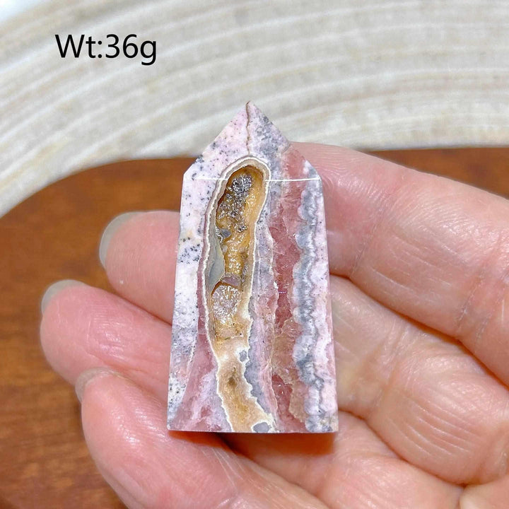 Polished Rhodochrosite tower point featuring rose pink banding and a unique crystal druzy center for heart chakra healing.