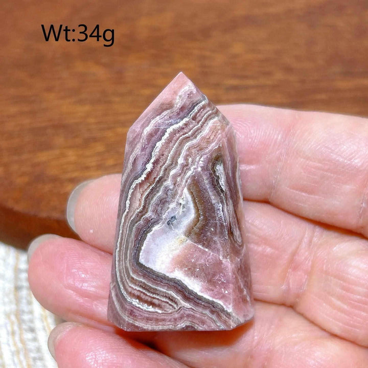 Polished 34g Rhodochrosite tower point featuring beautiful rose pink and white banding for heart chakra healing.