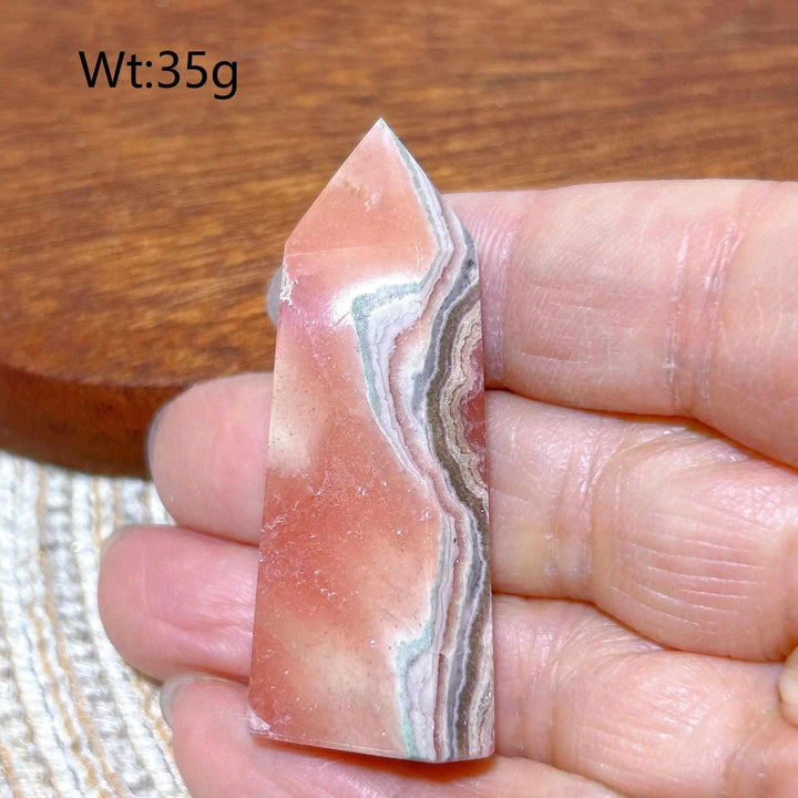 Polished 35g Rhodochrosite tower point featuring beautiful rose pink hues and soft white banding for heart chakra healing.