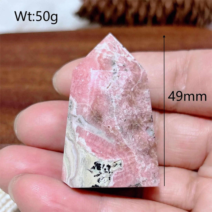 Polished Rhodochrosite tower point featuring raspberry pink hues and white banding, perfect for heart chakra healing.